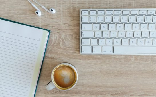 A work space with a keyboard and coffee