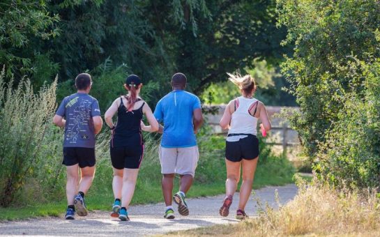 Four people running through the park