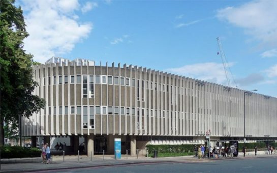 A picture of the external building of Swiss Cottage Library in Camden, taken from the opposite side of the road.