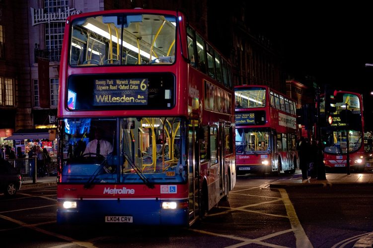 London buses driving through the city at night