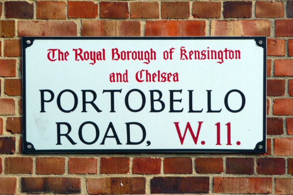 A street sign for Portobello Road in the Royal Borough of Kensington and Chelsea on a brick wall background