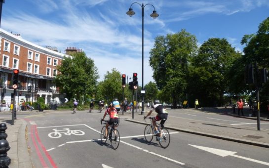 Two cyclists on their bikes by Chelsea Embankment